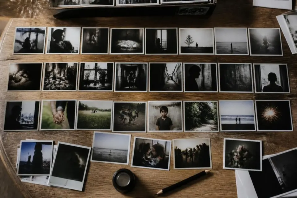 Printed photographs arranged in sequence on a table with a loupe